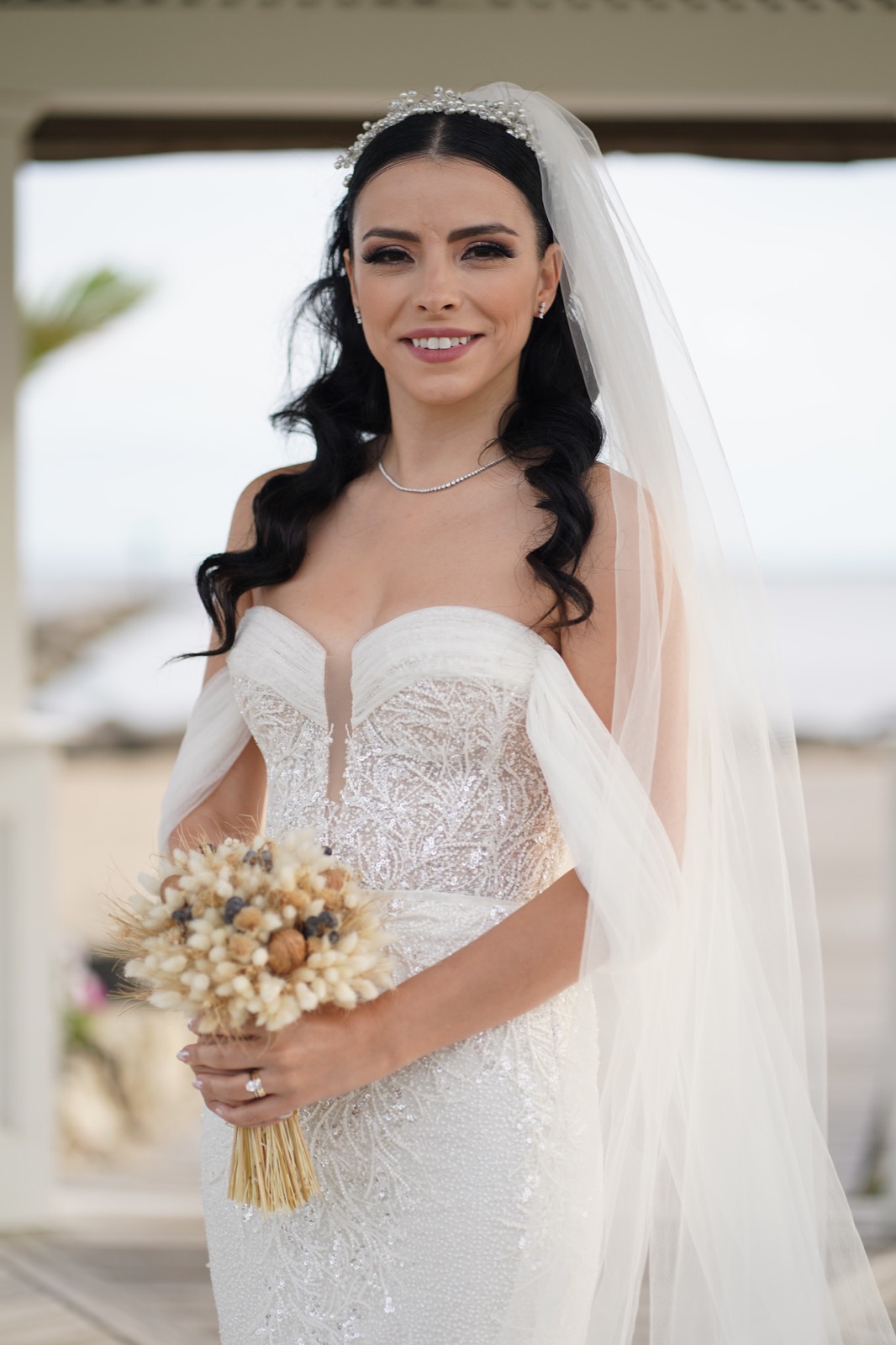 Smiling bride with a pearl tiara and dried flower bouquet